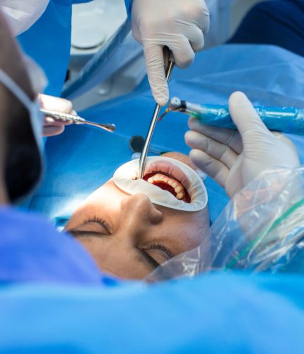 dentist and assistant with tool makes some manipulations in the patient's mouth